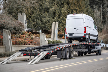 Powerful truck unloaded cargo mini van delivered on the car hauler semi trailer - obrazy, fototapety, plakaty