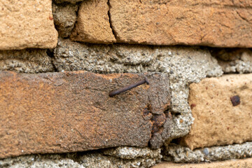  Old brickwall background. A nail hammered on red brickwall.