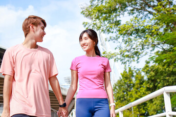 Obraz premium Young Asian couple exercising outdoors together. Sport concept. Healthy exercise.