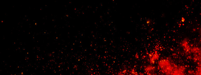 Fire embers particles over black background. Fire sparks background. Abstract dark glitter fire particles lights.	