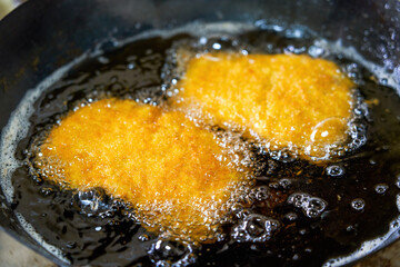 Delicious chicken chops are being fried in the kitchen oil pan