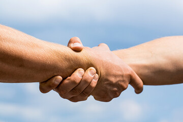 Friendly handshake, friends greeting, teamwork, friendship. Rescue, helping gesture or hands. Two...