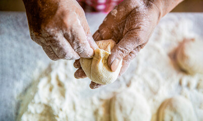 Homemade cakes dough in the women's hands. Process of making pies, hand. Hands pie dough. Cooks dough for baking, pieces of raw dough. Womans hands rolling doughs for pies. Baking at home - Powered by Adobe