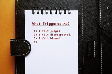 Notebook with handwritten text WHAT TRIGGERED ME? with list of Identify what triggerred or...