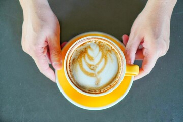 A cup of coffee with hands.