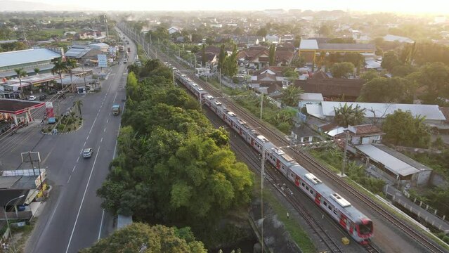 Aerial view of KRL Train in sunset near road in Indonesia