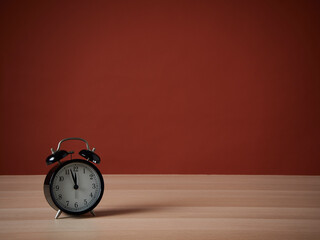 Alarm clock on light orange background