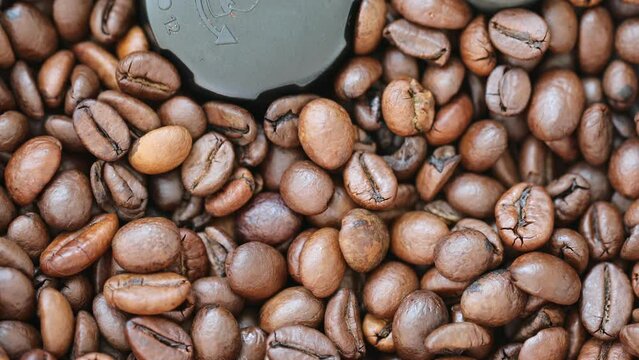 The coffee beans are ground by the coffee machine. Close-up of coffee beans, 4K video