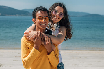 happy teenage couple hugging on the beach