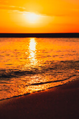 Reflection of sunlight over sea surface at sunset. Orange and gold blue sky. Scenic Gold sea....