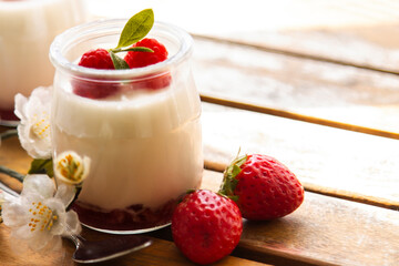 natural yogurt with strawberries on wooden background