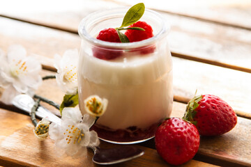 Greek yogurt with strawberries on wooden background