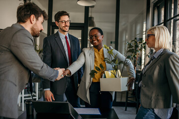 African American employee got a promotion and moved to another company and held a box of her...