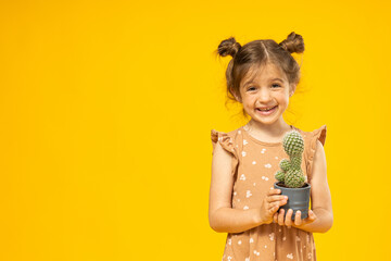 A little girl with a cactus in her hands, a bear for text