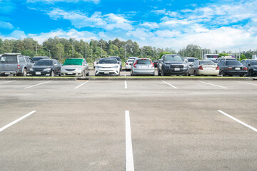 Wide empty asphalt parking lot background. with many cars parked background. outdoor empty space parking lot with trees and cloudy sky. outside parking lot in a park
