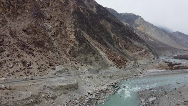 Aerial drone shot of KKH road along picturesque Karimabad Hunza Valley with Rakaposhi mountains in the background in Hunza, Balochistan.