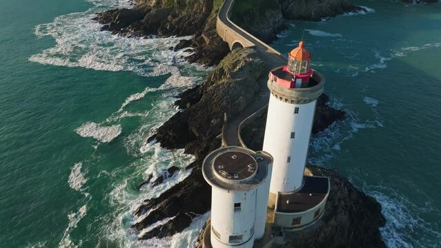 A man Riding a bike down the path of Phare du Petit in Bretagne France during sunset