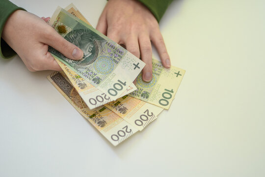 Polskie banknoty o dużych nominałach trzymane w ręce przez mężczyznę 