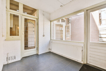 an empty room with white brick walls and large glass doors that open up to the outside, on a sunny day