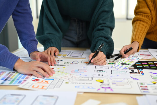 Cropped image of web developer team collaborating and planning template layout for mobile application in office