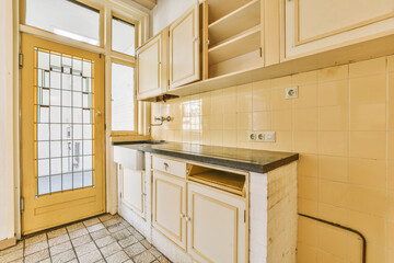 a kitchen with white cabinets and black counter tops on the floor in front of an open door that...