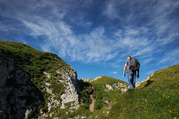 Fototapeta premium man hiking in the mountains with backpack on trails