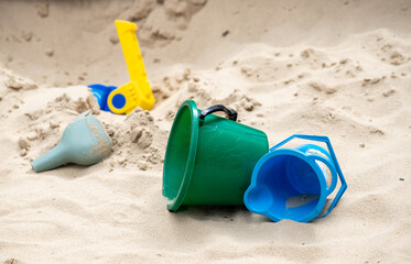 children's plastic toys on yellow sand