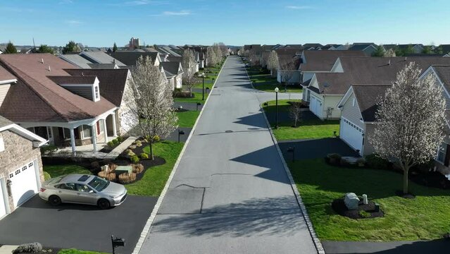 A beautiful push-back drone shot of a residential area in the USA. Aerial establishing shot of neighborhood in spring.