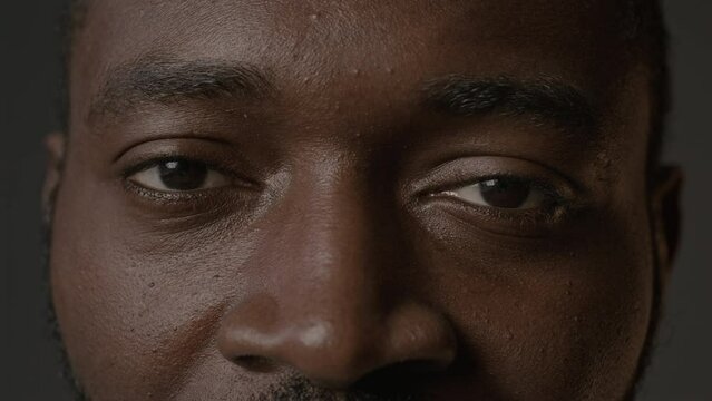 Extreme closeup portrait of young handsome Black man looking frustratedly at camera
