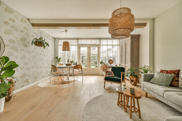 a living room with couches, chairs and plants on the wall in front of the door to the dining area