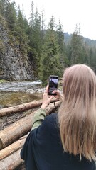 
Photo of a girl taking pictures of nature on her phone