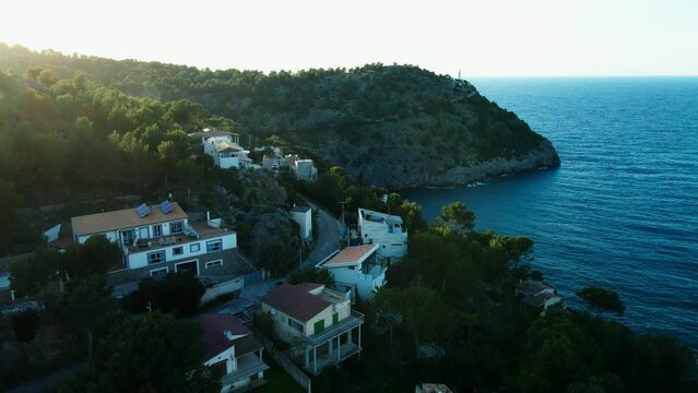 Luxury Spanish villas at sunset in Soller Mallorca on hot summer day with crystal clear ocean and green forest