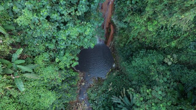 Descending into a tropical waterfall. Diamond Waterfall in Soufri&egrave;re Botanical Gardens in Saint Lucia. Lush rainforest on a tropical island, incredible landscape captured by drone, in 4K, 30fps.