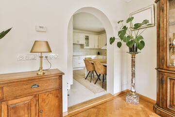 a living room with a dining table and an archway leading to the kitchen in the door is open on the right side