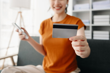 Asian woman hands using smartphone and holding credit card sitting. Online Shopping payments concept.