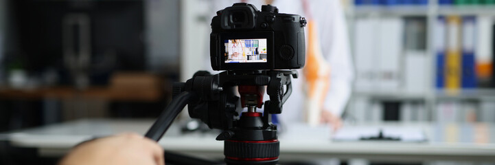 Videographer filming online broadcast about medicine in clinic with doctor. Remote video blog about...