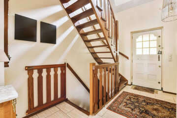 a stairway way in a house with wood railing and handrails on either side, leading up to the front...