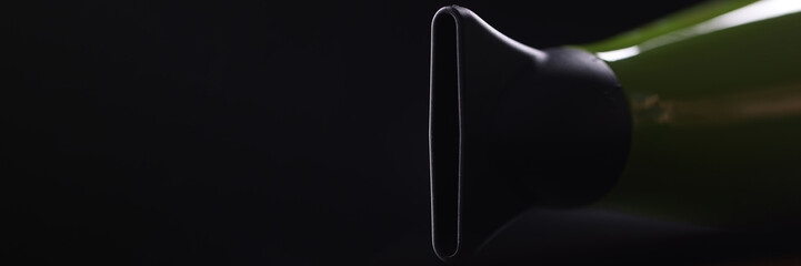 Green modern hair dryer with a flat nozzle on dark background. Choice of hair dryer and nozzles for hair styling concept