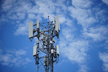 Telecommunication tower of 4G and 5G cellular. Macro Base Station. 5G radio network telecommunication equipment with radio modules and smart antennas mounted on a metal against cloulds sky background.