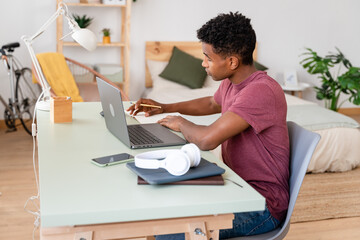 Young man working from desk at home.