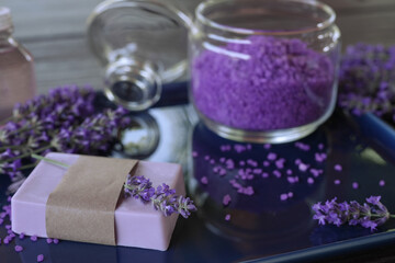 Obraz na płótnie Canvas Lavender Spa products and lavender flowers on a table. Handmade soap, essential oil and lavender bath salt - beauty treatment. Healthy skin care. SPA concept. Side view, copy space for text.