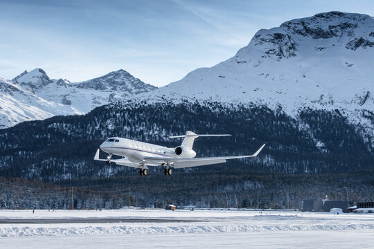 Luxury private jet approaching the engadin valley in the Swiss alps. This mountain resort is visited by many rich people during their winter vacations.	
