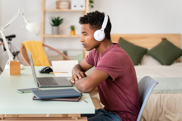 Man with wireless headphones working with laptop.