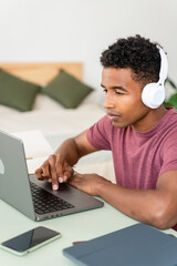 Man with wireless headphones working with laptop.