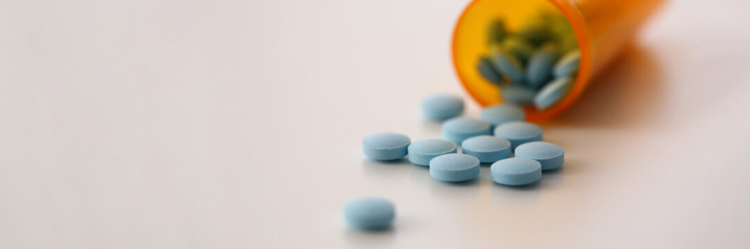 Medical round blue pills bottle with pills on table. Vitamins dietary supplements and medicines