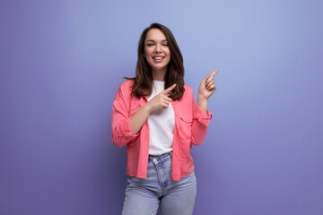 nice looking european brunette 30s woman in pink shirt with inspiration on studio background with copy space