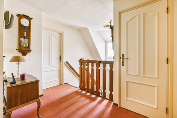 a room with an old clock on the wall and red carpeted floor in front of the door to another room
