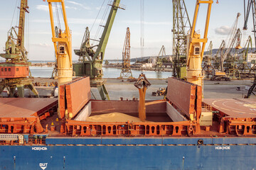 Cose up Black Sea port ukranian grain Loading process of dry cargo ship by harbor cranes. shallow...