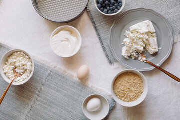 Flat lay of  ingredients for making cheesecake with blueberries, top view, copy space.