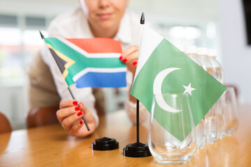 Little flag of Pakistan on table with bottles of water and flag of South Africa put next to it by...